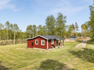 uma pequena cabina vermelha num campo relvado em Chalet Björkebo - HAL024 by Interhome em Ätran