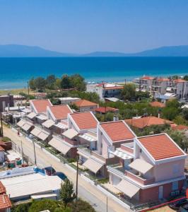 ariaal uitzicht op een stad met huizen en de oceaan bij Dionysos Residential Complex in Ofrínion