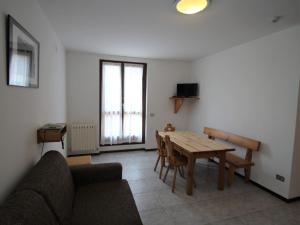 een woonkamer met een bank en een houten tafel bij Apartment Lembondel-5 by Interhome in Tiarno di Sotto