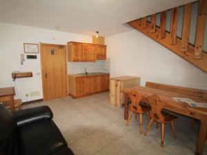 Apartment Lembondel-2 by Interhome في Tiarno di Sotto: مطبخ مع طاولة خشبية ودواليب خشبية
