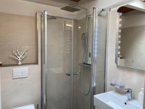 a bathroom with a shower and a sink at Holiday Home Mondmuschel by Interhome in Norddeich