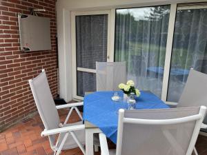 a table with a blue table cloth on a patio at Holiday Home Mondmuschel by Interhome in Norddeich