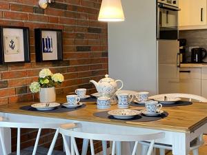 a dining room table with a tea set on it at Holiday Home Mondmuschel by Interhome in Norddeich