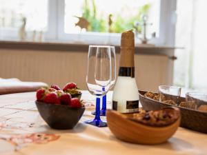 a bottle of champagne and a bowl of fruit on a table at Apartment Fielapper by Interhome in Norddeich