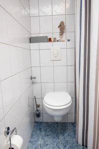 ein Bad mit einem WC in einer weiß gefliesten Wand in der Unterkunft Apartment Fielapper by Interhome in Norddeich