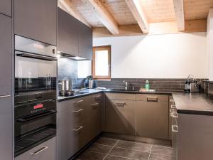 d'une cuisine avec des appareils en acier inoxydable et des plafonds en bois. dans l'établissement Apartment TITLIS Resort 4-Zimmer Dachwohnung 6, à Engelberg