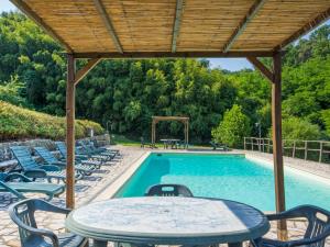a swimming pool with chairs and a table and a table and a wooden roof at Villa Nicoletta by Interhome in Serravalle Pistoiese +51 photos