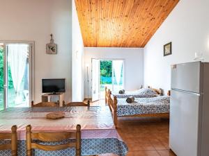 ein Wohnzimmer mit 2 Betten und einem Kühlschrank in der Unterkunft Holiday Home La Pinede - SAG171 by Interhome in Sagone