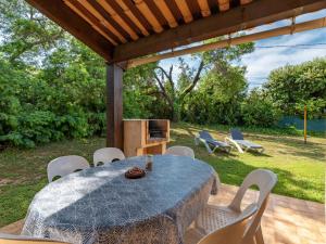 einen Tisch und Stühle unter einer Pergola in der Unterkunft Holiday Home La Pinede - SAG171 by Interhome in Sagone