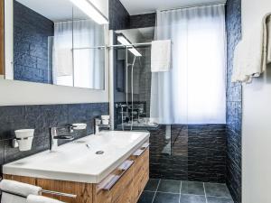 ein Bad mit einem Waschbecken und einer Dusche in der Unterkunft Apartment TITLIS Resort 4-Zimmer Dachwohnung 5 in Engelberg