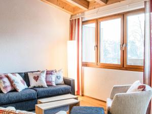 ein Wohnzimmer mit einem Sofa und einem Fenster in der Unterkunft Apartment TITLIS Resort 4-Zimmer Dachwohnung 5 in Engelberg