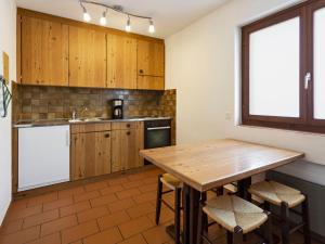 eine Küche mit Holzschränken und einem Holztisch in der Unterkunft Apartment Resort al Centro-3 by Interhome in Massagno