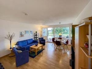 a living room with a blue couch and a table at Apartment G 16 by Interhome in Dittishausen