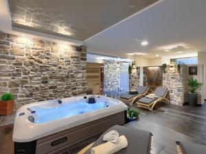 a large bathroom with a large tub in a stone wall at Holiday Home Panorama 1 by Interhome in Labin