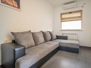 a couch in a living room with a window at Apartment Miškulin-3 by Interhome in Senj