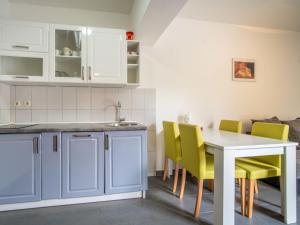 a kitchen with a white table and yellow chairs at Apartment Miškulin-3 by Interhome in Senj +28 photos