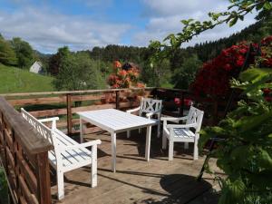 une table et des chaises blanches sur une terrasse en bois dans l'établissement Holiday Home Gamlahuset - FJH667 by Interhome, à Bruntveit