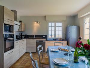 LandunvezにあるHoliday Home Saint Gonvel - LDZ103 by Interhomeのキッチン(テーブル、椅子、冷蔵庫付)