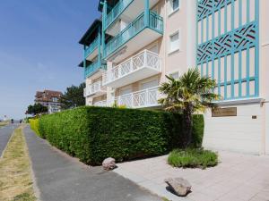 a building with a palm tree in front of it at Apartment Hortensia by Interhome in Cabourg