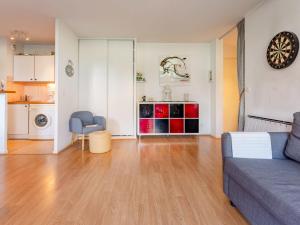 a living room with a couch and a kitchen at Apartment Hortensia by Interhome in Cabourg