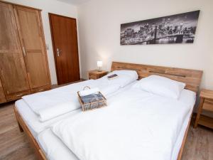 ノルトダイヒにあるApartment Sandburg by Interhomeの白いシーツが敷かれたベッドが2つある寝室