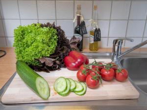 a cutting board with tomatoes and vegetables on a kitchen counter at Apartment Strandkorb by Interhome in Norddeich