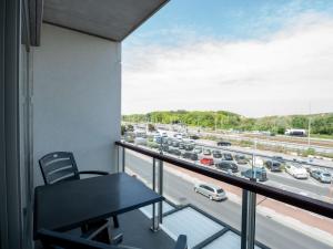 een balkon met een tafel en uitzicht op een snelweg bij Apartment Residentie Lautrec-1 by Interhome in Bredene