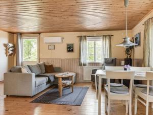 - un salon avec un canapé et une table dans l'établissement Holiday Home Lunnekullen - VGT122 by Interhome, à Tibro