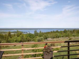 a flower pot on a fence with a view of the water at Holiday Home Lunnekullen by Interhome in Tibro +17 photos