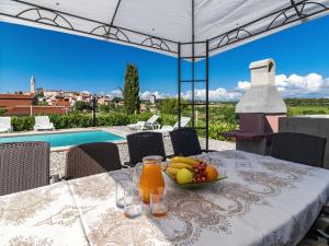 a table with a bowl of fruit and juice on it at Holiday Home Jurican - KST417 by Interhome in Višnjan