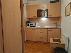 eine kleine Küche mit Holzschränken und einer Mikrowelle in der Unterkunft Apartment Rosa-8 by Interhome in Mayrhofen