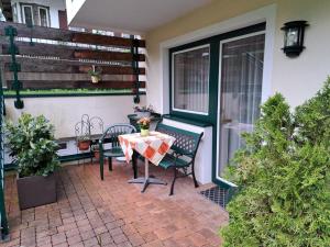 eine Terrasse mit einem Tisch, Stühlen und einem Fenster in der Unterkunft Apartment Rosa-8 by Interhome in Mayrhofen