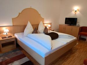 a bedroom with a large bed with white sheets and pillows at Apartment Rosa-8 by Interhome in Mayrhofen