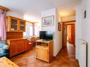 a living room with a flat screen tv and a kitchen at Apartment Cesa Pra da Molin-2 by Interhome in Campitello