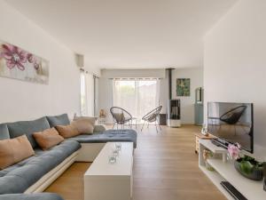 un soggiorno con divano blu e TV di Villa Villa Les Cygnes by Interhome a LʼAubraie