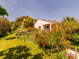 una casa con flores delante en Villa Villa Les Cygnes by Interhome en LʼAubraie