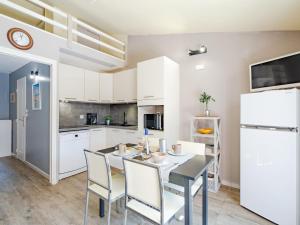 a kitchen with a table and chairs and a refrigerator at Apartment Le Thalassa 1 by Interhome in Sainte-Maxime