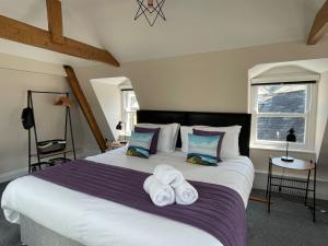 um quarto com uma cama grande e toalhas em Grisedale Pike em Keswick