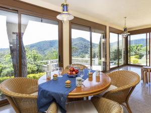 a dining room with a table and chairs and mountains at Villa Venecia by Interhome in Calonge