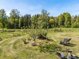 Lekeryd的住宿－Holiday Home Djuvarp Ängen - SND117 by Interhome，田野里两把椅子和一棵树