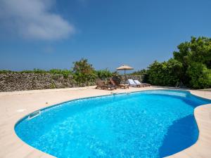 a swimming pool with blue water in a yard at Villa Les 4 Vents by Interhome in Saint-Aygulf