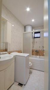 a white bathroom with a sink and a toilet at Apartment Glomazic in Budva