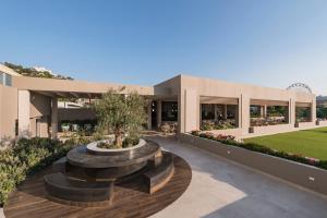a building with a fountain in front of it at Esperides Beach Resort in Faliraki
