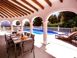 Villa Villa Alta Vista by Interhome في Muntanya la Sella: فناء خارجي مع طاولة وكراسي ومسبح