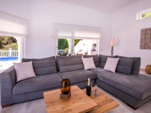 een woonkamer met een grijze bank en een tafel bij Villa Villa Alta Vista by Interhome in Muntanya la Sella