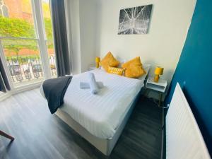 a small bedroom with a bed with yellow pillows at Avalon Hotel in Brighton & Hove +41 photos