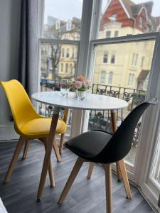 einen Tisch und Stühle in einem Zimmer mit Fenster in der Unterkunft Avalon Hotel in Brighton & Hove