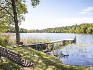 a bench sitting next to a dock on a lake at Chalet Mjöhult Skogen - HAL022 by Interhome in Ätran
