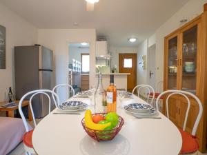 een witte tafel met een schaal fruit erop bij Apartment Le Mas des Calanques-1 by Interhome in Saint-Aygulf +31 foto's