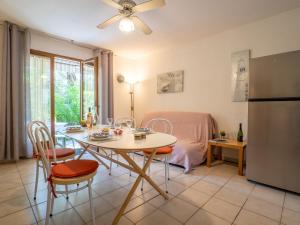 a kitchen and dining room with a table and a refrigerator at Apartment Le Mas des Calanques-1 by Interhome in Saint-Aygulf